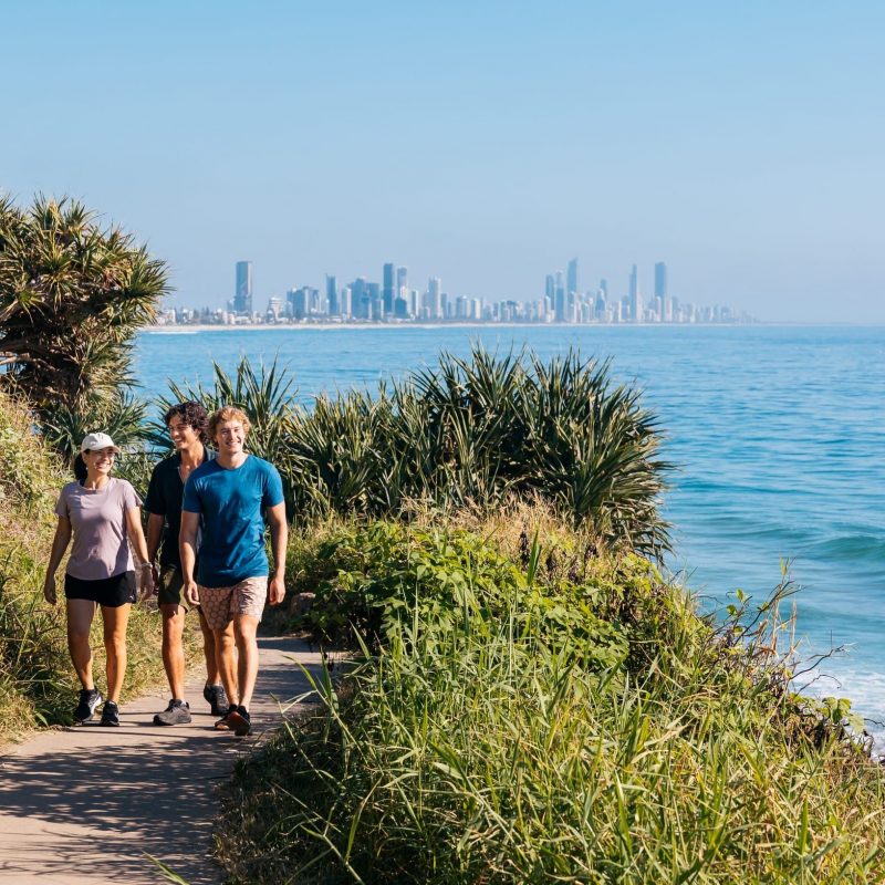 Group of friends walking along the oceanfront pathway through the National Park